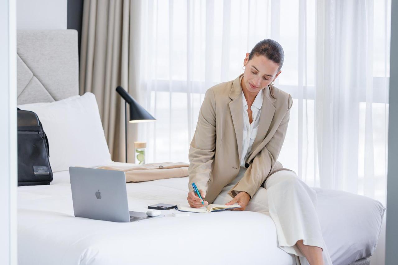 Meriton Suites Zetland Сидни Екстериор снимка A business traveller working in a hotel room